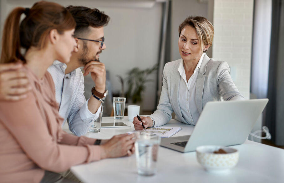 Three people having a meeting and looking at a lapto