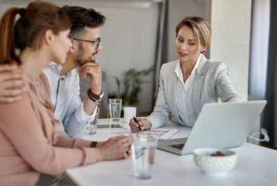 Three people having a meeting and looking at a lapto