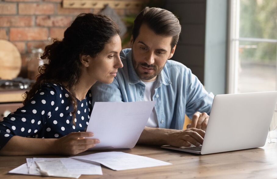 A couple sat in front of a laptop