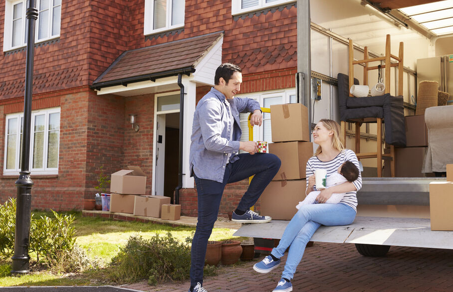 Two people in front of a moving van moving houses