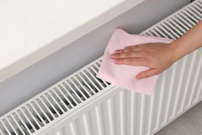 A person's hands on a radiator