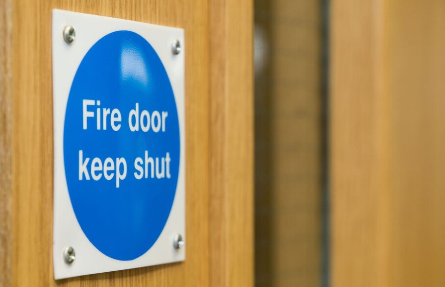 A sticker on a door that says Fire door keep shut