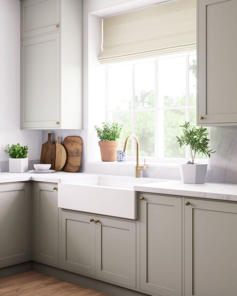 An elegant kitchen that features a charming farmhouse sink, abundant greenery, and sleek, modern cabinetry