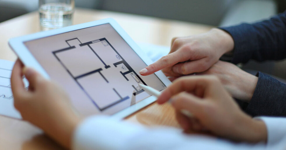 Estate agent showing house plans on tablet