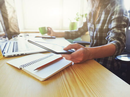 hands with tablet, coffee and laptop at table