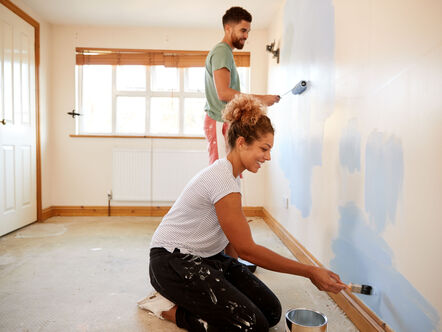 Young couple painting a wall 