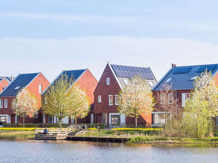 A row of home in front of a body of water