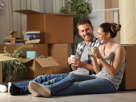 Happy couple sat on floor 