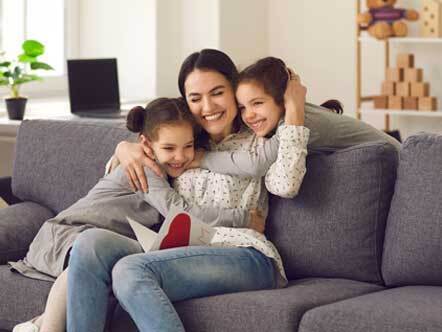 Happy loving mother hugs her daughters